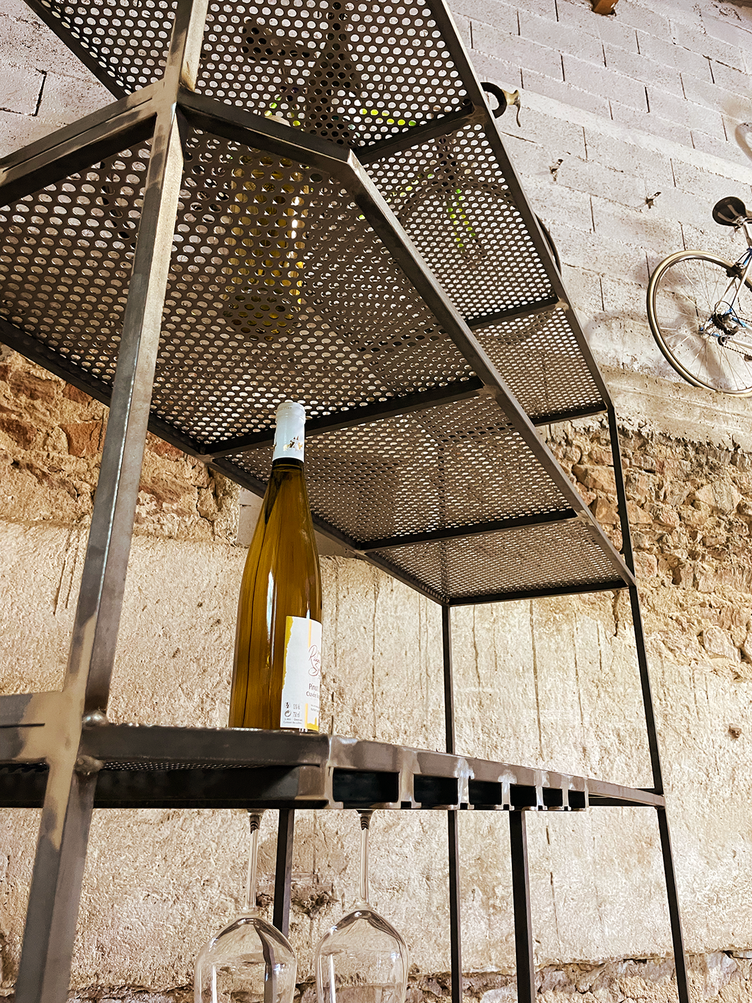 Détail de l'étagère sur mesure avec vue sur la tôle perforée et sur les range-verres sur mesure