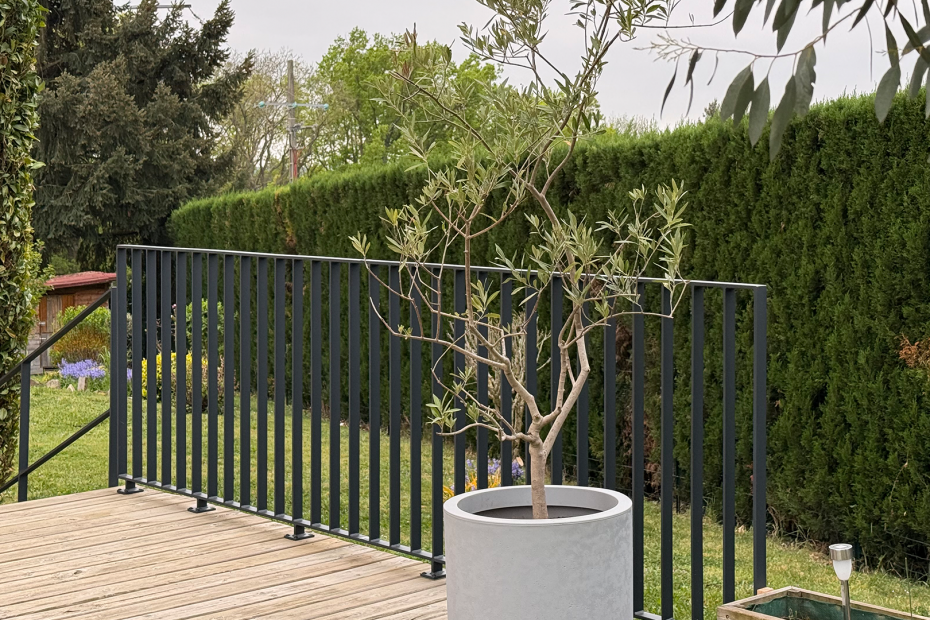 Garde-corps de terrasse réalisé en plat avec au premier plan un laurier en pot
