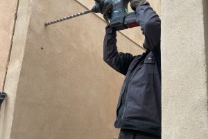 Alexandre Artzt en train de percer un trou dans un mur pour installer un portillon
